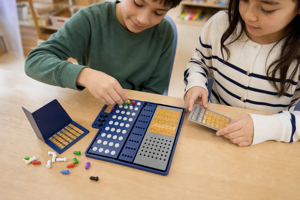 Two primary learners using the Kodmaster board to create and test a hidden color code